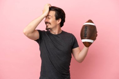 Pembe arka planda ragbi oynayan genç beyaz adam bir şeyin farkına vardı ve çözüme niyetlendi.