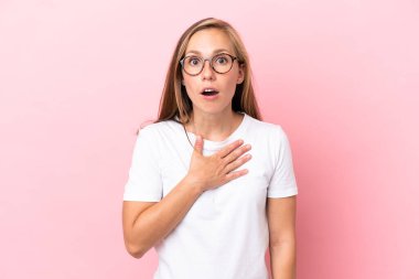 Pembe arka planda izole edilmiş genç bir İngiliz kadın sağa bakarken şaşırmış ve şok olmuştu.