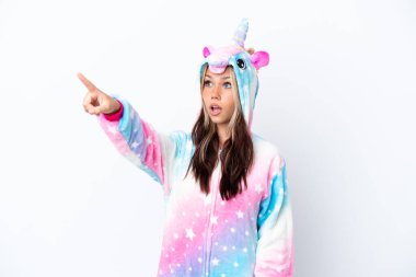 Beyaz arka planda izole edilmiş tek boynuzlu at pijaması giyen genç Rus kadın...