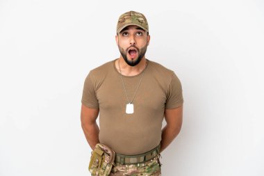 Genç Arap asker beyaz arka planda izole edilmiş yukarı bakıyor ve şaşırmış bir ifadeyle