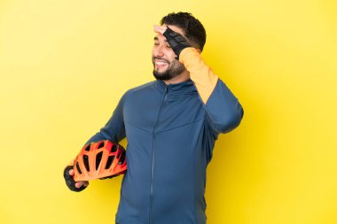 Genç bisikletçi Arap adam sarı arka planda izole edilmiş, çok gülümsüyor.
