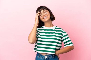 Genç melez kadın pembe arka planda izole edilmiş, çok gülümsüyor.