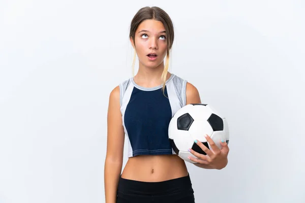 배경에서 고립된 축구를 코카서스 소녀가 표정으로 올려다보며 — 스톡 사진