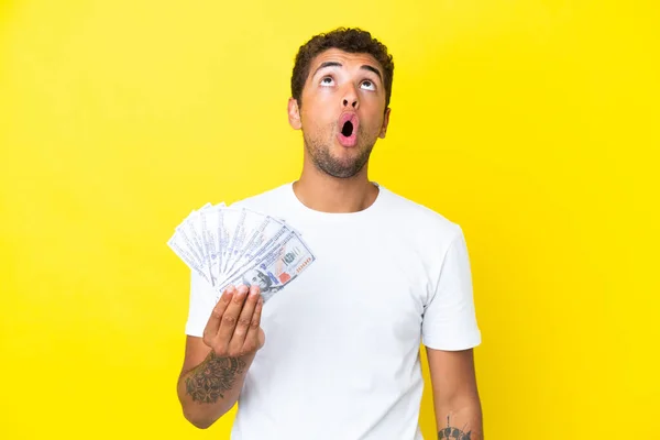 Jonge Braziliaanse Man Neemt Veel Geld Geïsoleerd Gele Achtergrond Zoek — Stockfoto