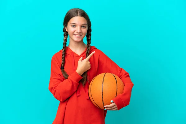 Niña Caucásica Jugando Baloncesto Aislada Sobre Fondo Azul Apuntando Hacia — Foto de Stock