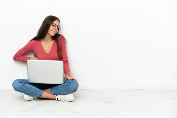 年轻的法国姑娘坐在地板上 她的笔记本电脑因为付出了巨大的努力而感到背痛 — 图库照片