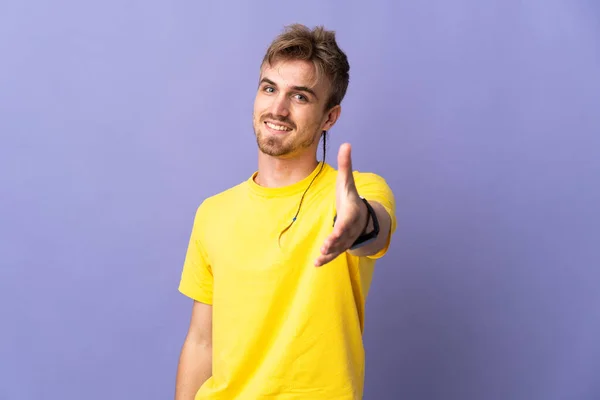 Mladý Pohledný Blondýnka Muž Izolovaný Fialové Pozadí Třesoucí Ruce Pro — Stock fotografie