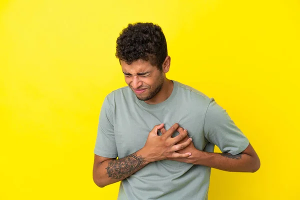 Jovem Brasileiro Bonito Isolado Fundo Amarelo Com Uma Dor Coração — Fotografia de Stock