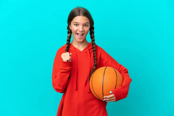 在蓝色背景下孤身一人打篮球庆祝胜利的高加索小女孩 — 图库照片