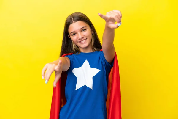 小さなCaucasianスーパーヒーロー女の子絶縁上の黄色Backgroundポイント指であなたに笑顔 — ストック写真