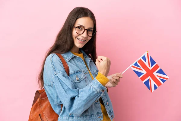 ピンクの背景に隔離された英国の旗を持っている若いフランスの女の子は勝利を祝う — ストック写真