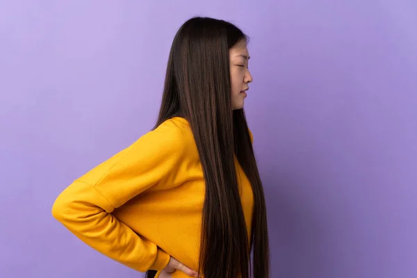 Ung Kinesisk Flicka Över Isolerad Lila Bakgrund Lider Ryggvärk För — Stockfoto