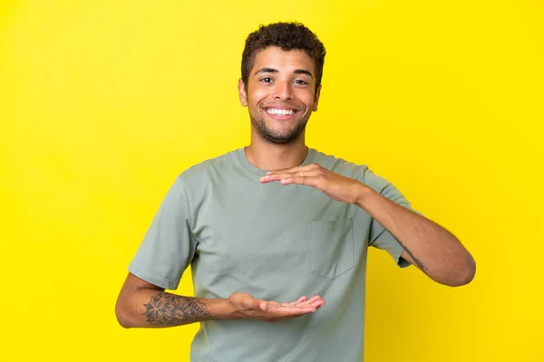 Ung Stilig Brasiliansk Man Isolerad Gul Bakgrund Håller Copyspace Imaginära — Stockfoto