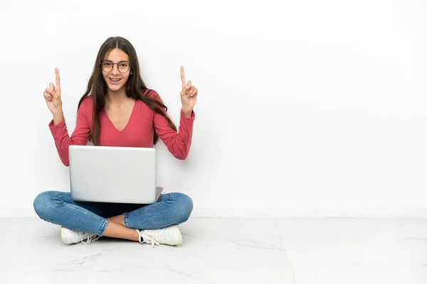 年轻的法国姑娘坐在地板上 她的笔记本电脑指向一个伟大的想法 — 图库照片