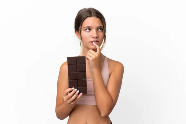 Malá Kavkazská Dívka Izolované Bílém Pozadí Čokoládovou Tabletu Mají Pochybnosti — Stock fotografie