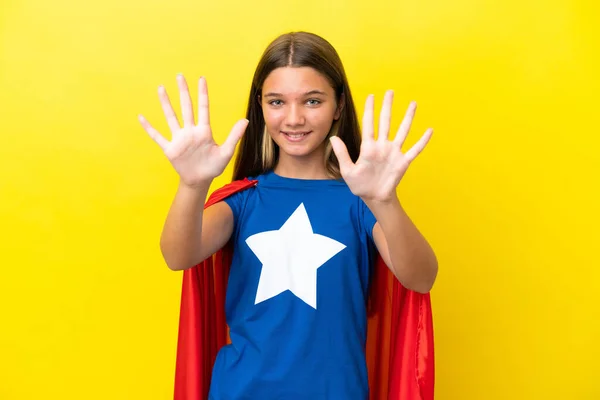 小さいですCaucasianスーパーヒーロー女の子絶縁オンイエローバックカウント10とともに指 — ストック写真