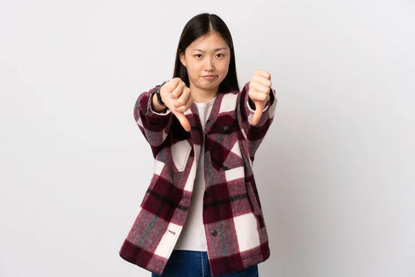 年轻的中国女孩 在孤独的白色背景上用双手握住大拇指 — 图库照片
