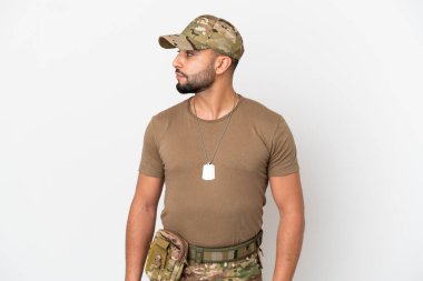 Genç Arap asker beyaz arka planda izole edilmiş bir şekilde yan tarafa bakıyor.