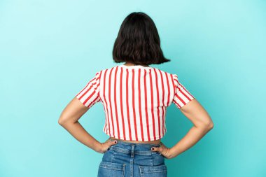 Genç melez kadın arka planda mavi arka planda izole edilmiş.