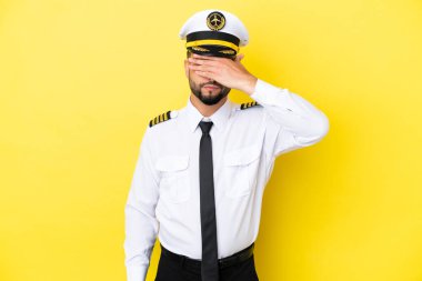 Uçak Arap pilotu sarı arka planda tek başına, gözleri elle kapatıyor. Bir şey görmek istemiyorum.