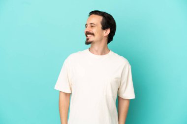 Genç beyaz adam mavi arka planda izole edilmiş.