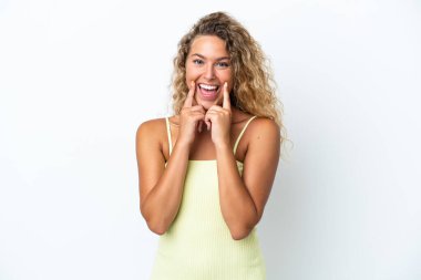 Beyaz arka planda izole edilmiş kıvırcık saçlı mutlu ve hoş bir ifadeyle gülümseyen bir kız.