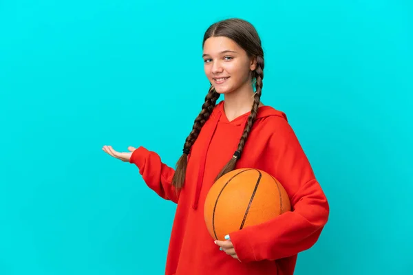 卡西亚小女孩在蓝底背景下孤身一人打篮球 她向旁边伸出手来邀请大家来 — 图库照片