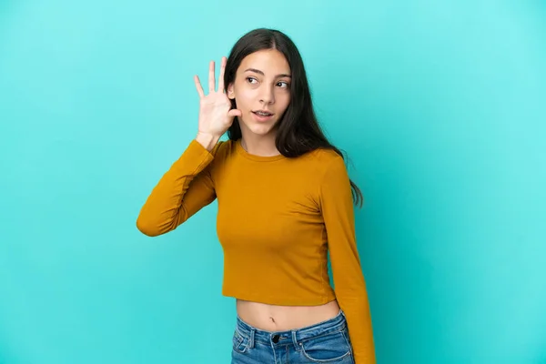 Joven Francesa Aislada Sobre Fondo Azul Escuchando Algo Poniendo Mano —  Fotos de Stock