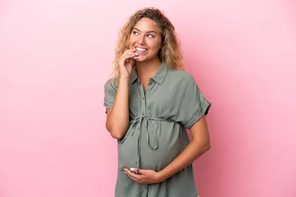 Ragazza Con Capelli Ricci Isolati Sfondo Rosa Incinta Pensando — Foto Stock