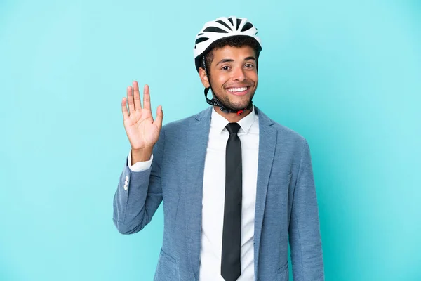 Junger Geschäftsmann Brasilianischer Abstammung Mit Fahrradhelm Auf Blauem Hintergrund Salutiert — Stockfoto