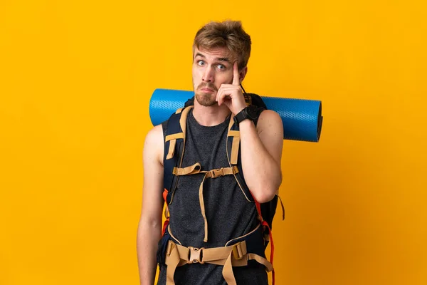 Jonge Bergbeklimmer Met Een Grote Rugzak Geïsoleerd Gele Achtergrond Denkend — Stockfoto