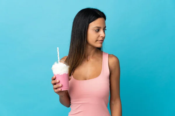 横を向いているイチゴミルクシェイクを持つ若い女性 — ストック写真