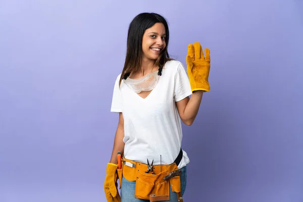 幸せな表情で手で紫色の背景塩漬けに隔離された若い電気技師の女性 — ストック写真