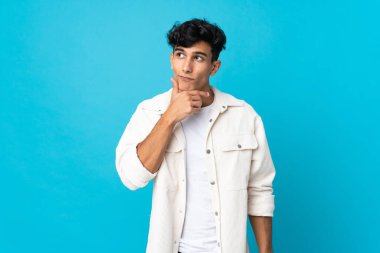 Arjantinli genç adam arka planda izole edilmiş bir şekilde bir fikir ararken...