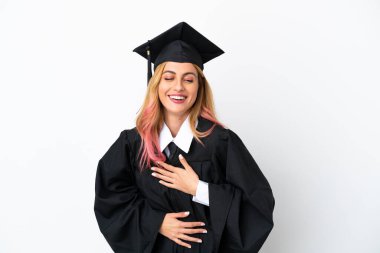 Tecrit edilmiş beyaz bir arka planda genç üniversite mezunu. Çok gülümsüyor.