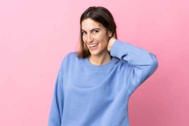 Pembe arka planda izole edilmiş genç beyaz kadın gülüyor.