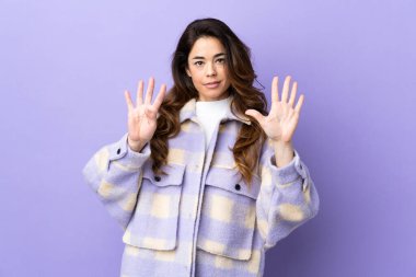 İzole edilmiş mor arka planda dokuz parmaklı kadın.