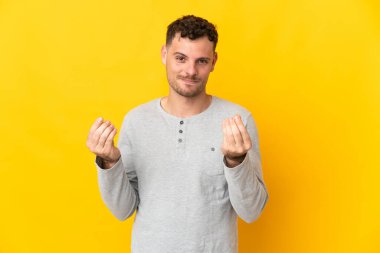 Sarı arka planda izole genç beyaz yakışıklı adam para hareketi yapıyor ama mahvoldu.