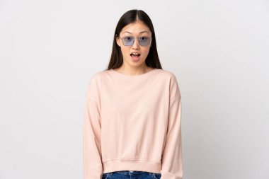 Yüzünde sürpriz ifade olan, izole edilmiş beyaz bir geçmişi olan genç Çinli bir kız.