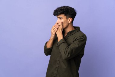 Arjantinli genç adam arka planda izole edilmiş ağzını kapatıyor ve yan tarafa bakıyor.