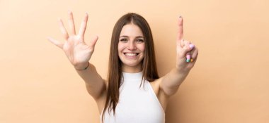 Beyazlı genç bir kadın bej arka planda izole edilmiş. Parmakları olan altı kişi saydım.