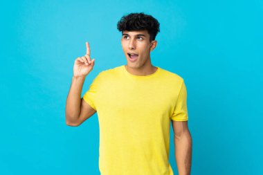 Arjantinli genç bir adam arka planda izole edilmiş bir şekilde parmağını kaldırarak çözümü anlamaya çalışıyor.