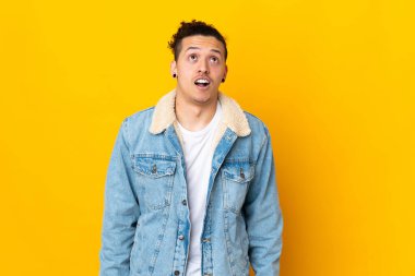 İzole edilmiş arka planda beyaz bir adam yukarı bakıyor ve şaşırmış bir ifadeyle