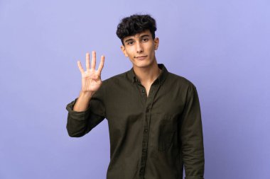 Arjantinli genç adam arka planda izole edilmiş mutlu ve parmaklarıyla dört kişi sayıyor.