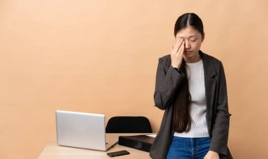 İş yerinde başı ağrıyan Çinli bir iş kadını.