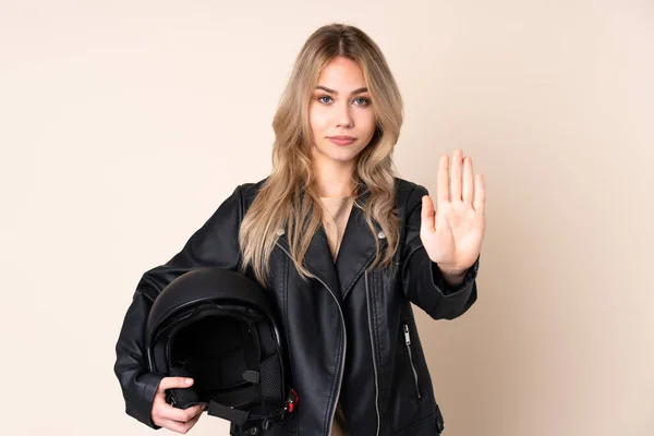 오토바이 헬멧을 러시아 소녀가 베이지 배경에서 고립되어 제스처를 — 스톡 사진