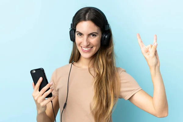 Jovem Caucasiana Isolada Fundo Rosa Ouvindo Música Com Gesto Rock — Fotografia de Stock