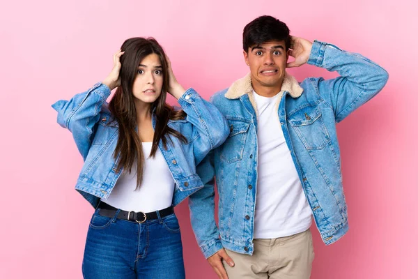 Casal Jovem Sobre Fundo Rosa Isolado Leva Mãos Cabeça Porque — Fotografia de Stock