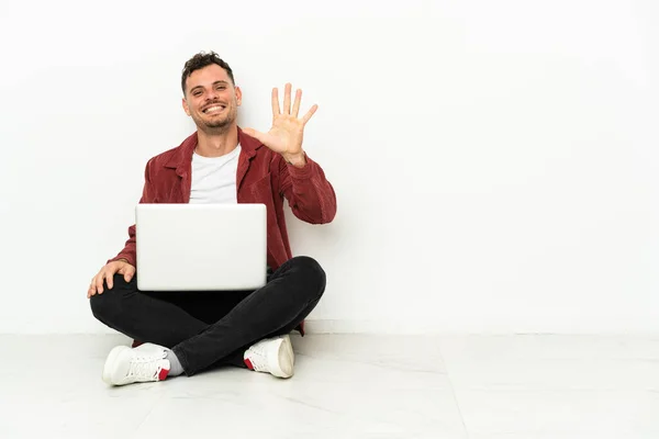 Jovem Bonito Caucasiano Sentar Chão Com Laptop Contando Cinco Com — Fotografia de Stock