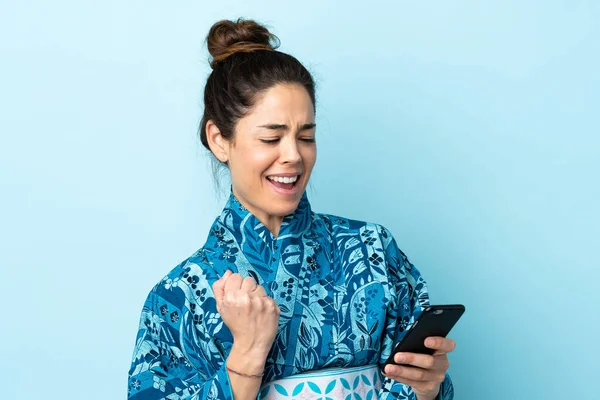 Femme Portant Kimono Sur Fond Isolé Avec Téléphone Position Victoire — Photo